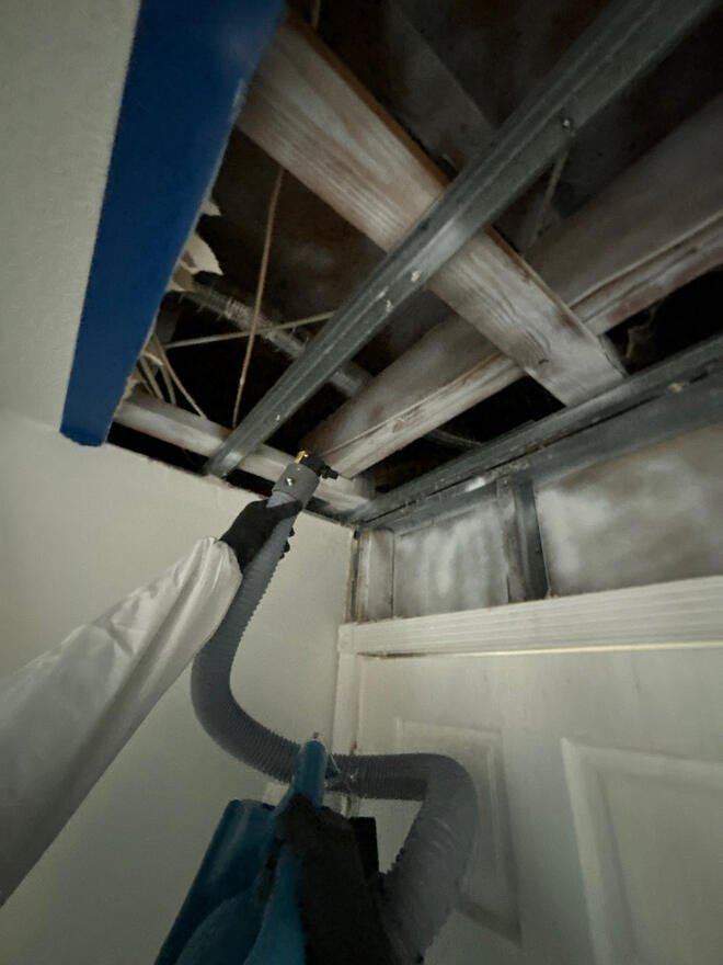 Technician fogging the exposed ceiling framing