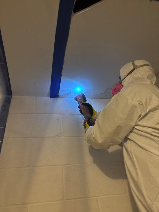 Technician in a protective suit and respirator
